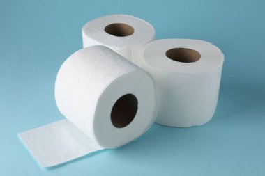 Açık mavi arkaplanda tuvalet kağıdı ruloları, yakın plan