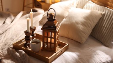 Güzel bir Noel feneri, yanan mumlar ve sıcak bir bardak içecekle birlikte.