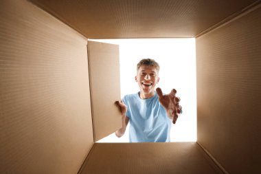 Adam beyaz arka planda karton kutuya bakıyor, içeriden görüntüle