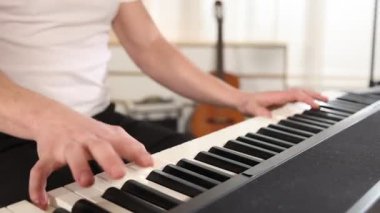 Evde sentezleyici çalan adam, yakın plan. Müzik aleti