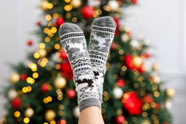 Evde Noel ağacına karşı rahat çorap giyen bir kadın, yakın plan.