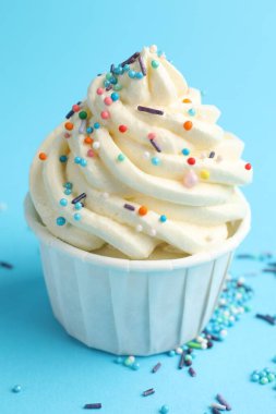 Açık mavi arka planda serpiştirilmiş lezzetli kek, yakın plan.