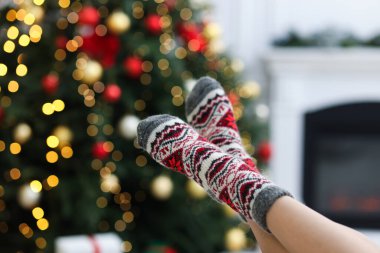 Evde Noel ağacına karşı rahat çorap giyen bir kadın, yakın plan.