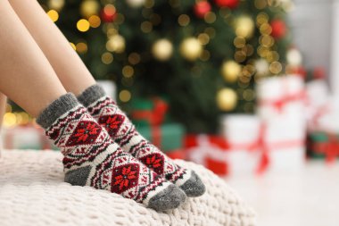 Evde Noel ağacına karşı rahat çorap giyen bir kadın, yakın plan. Metin için boşluk
