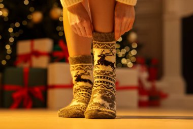 Noel ağacına karşı rahat çoraplar giyen kadın, yakın plan.