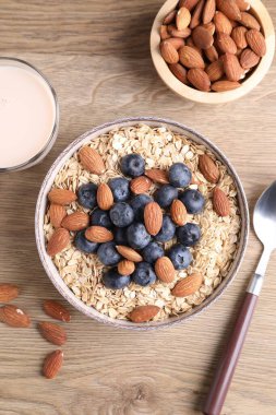 Yulaf gevreği, badem sütü, böğürtlen ve fındık, ahşap masa, düz uzanmış.