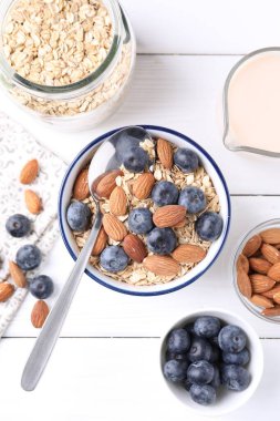 Yulaf gevreği, badem sütü, yaban mersini ve fındık beyaz ahşap masa, düz yatıyordu.