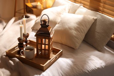 Güzel bir Noel feneri, yanan mumlar ve sıcak bir bardak içecekle birlikte.