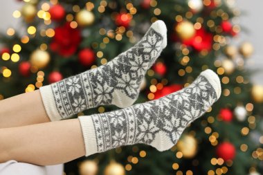 Evde Noel ağacına karşı rahat çorap giyen bir kadın, yakın plan.