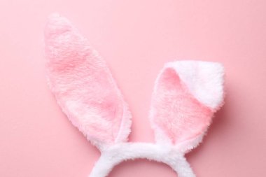 Pembe arka planda tavşan kulaklı şirin saç bandı, üst manzara. Mutlu Paskalyalar