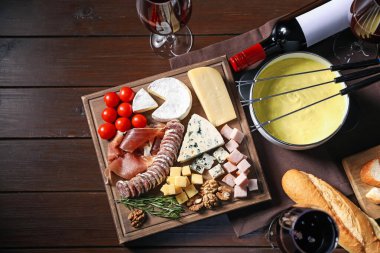 Erimiş peynir, şarap ve abur cuburla fondü tenceresi (caquelon).