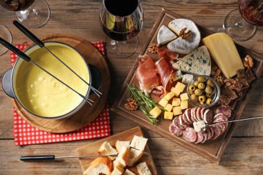 Erimiş peynir, şarap ve abur cuburla fondü tenceresi (caquelon).