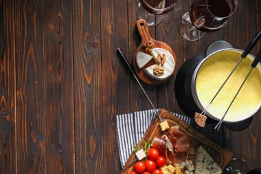 Erimiş peynir, şarap ve abur cuburla fondü tenceresi (caquelon). Metin için boşluk