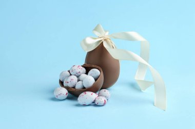 Açık mavi arka planda çikolatalı yumurta ve şeker. Mutlu Paskalyalar