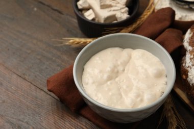 Hamur mayası ve malzemeler ahşap masada, yakın plan.