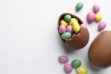 Beyaz arka planda çikolatalı Paskalya yumurtaları ve şekerler. Metin için boşluk