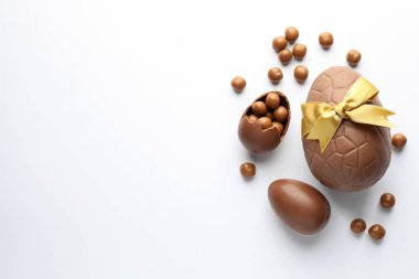 Beyaz arka planda çikolatalı Paskalya yumurtaları ve şekerler. Metin için boşluk
