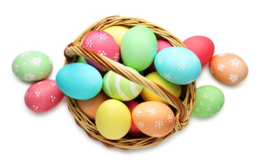 Hasır sepete boyanmış Paskalya yumurtaları. Beyaz, üst manzara.