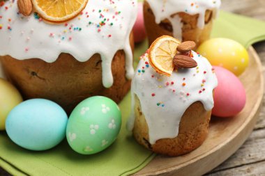 Nefis dekore edilmiş Paskalya pastaları ve yumurtalar ahşap masada, yakın plan.