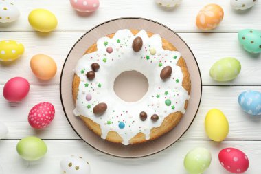 Lezzetli Paskalya pastası ve beyaz ahşap masaya boyanmış yumurtalar.