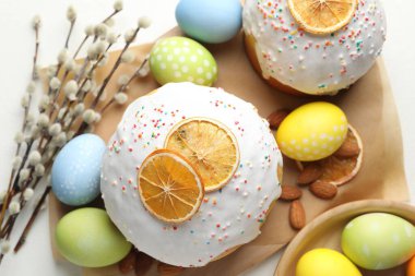 Lezzetli Paskalya pastaları, boyanmış yumurtalar ve söğüt dalları beyaz masada, düz yatıyordu.