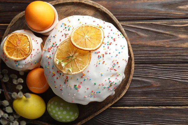 Güzel Paskalya pastaları, yumurtalar ve söğütler ahşap masada, düz yatıyordu.