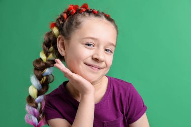 Yeşil arka planda şık örgüleri olan tatlı bir kız.