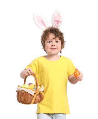 Paskalya kutlaması. Saçbandı takmış, tavşan kulaklı gülümseyen bir çocuk elinde sepet dolusu beyaz arka planda boyalı yumurta tutuyor.