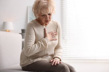 Kalp krizi geçirdi. İçeride göğüs ağrısı çeken yaşlı bir kadın. Metin için boşluk