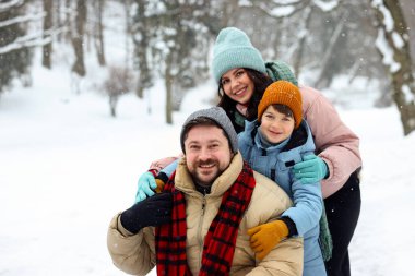 Mutlu aile, kış günü dışarıda birlikte vakit geçirir.