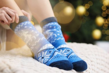 İçerde rahat çoraplar giyen bir kadın, yakın plan. Bokeh etkisi