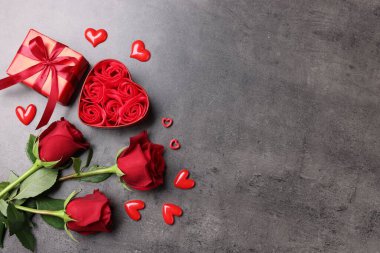 Güzel güller, hediye ve gri arka planda dekoratif kalpler, düz yatış. Metin için boşluk