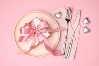 Pembe arka planda hediyeli zarif masa ayarı, düz yatış