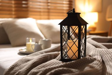 Güzel bir Noel feneri, yanan mumlar ve sıcak bir bardak içecekle birlikte.