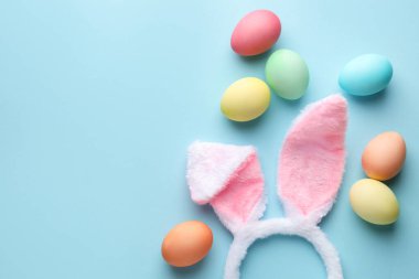 Mutlu Paskalyalar. Şirin tavşan kulakları ve açık mavi arka planda yumurtalar, düz bir şekilde yatıyordu. Metin için boşluk