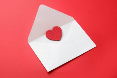 Sevgililer Günü tebrik kartı. Kırmızı arkaplanda dekoratif bir kalbe sahip zarf, yakın plan