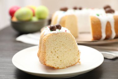 Paskalya pastasını kes ve ahşap masaya yumurta boya, yakın plan.