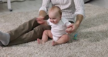 Babası evde küçük sevimli bebeğiyle, yakın plan. Kamera ileri ve geri hareket ediyor