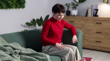 Ekoseli kadın evdeki kanepede dinleniyor.