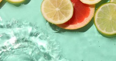 Turkuaz arka planda sudaki narenciye dilimleri, düzlük.