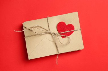 Stack of love letters on red background, top view