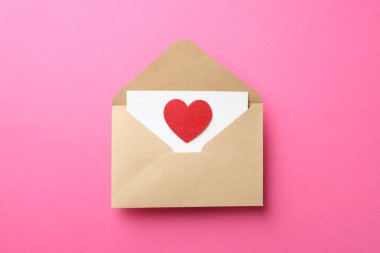 Tebrik kartı ve pembe arka planda dekoratif kalp ile zarf, üst görünüm