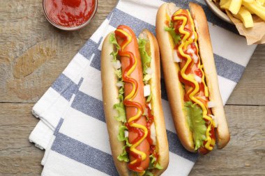 Soslu lezzetli sosisler, marul ve patates kızartması ahşap masada, düz yerde