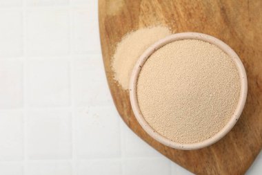 Beyaz fayanslı masada, kasede kuru maya, üst manzara. Metin için boşluk