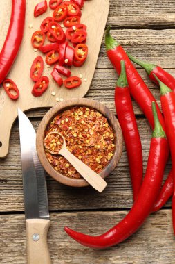 Kırmızı biber, gevrek ve bıçak tahta masada, düz yerde.