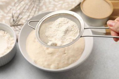 Işık masasında hamurla un karıştıran kadın, yakın plan.