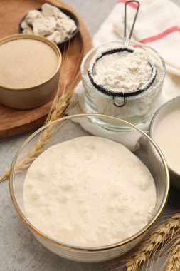 Çiğ hamur, malzemeler ve çiviler gri masada, yakın plan.