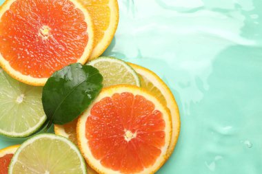 Turkuaz arka planda turkuaz meyveler ve yeşil yaprak dilimleri. Metin için boşluk