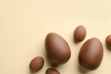 Paskalya kutlaması. Sarı arka planda bir sürü çikolata yumurtası, düzlük ve metin için boşluk.