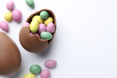 Beyaz arka planda çikolatalı Paskalya yumurtaları ve şekerler. Metin için boşluk